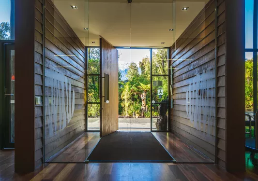 Doorway entry with a glass door and wooden panels on either side
