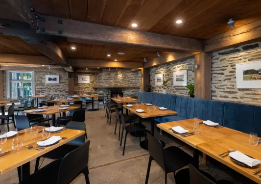 Restaurant with blue benches and wooden dining tables