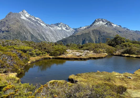 Small lake surrounded by large mountains and hills