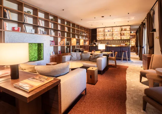 Bar and lounge with beige sofas and shelves full of books