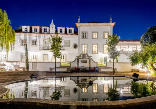 Exterior view of white building with with a fountain in front