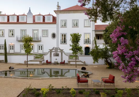 Exterior view of white and red building with an fountain in front