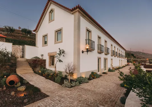 Exterior view of a beige building with stone accents, and a stone pathway in front