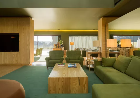 Seating area with green sofas and and wooden furniture