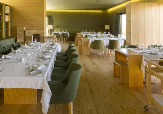 Dining area with green chairs and white table cloths
