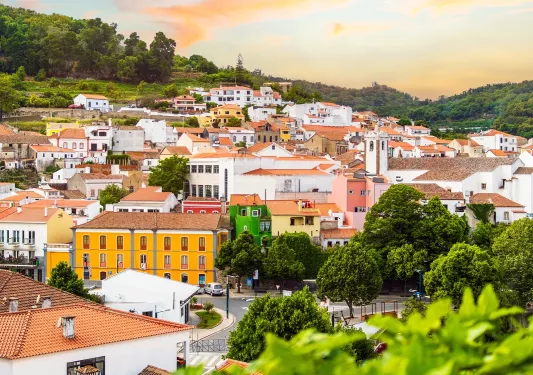 View of houses along a hill with the sunset in the background