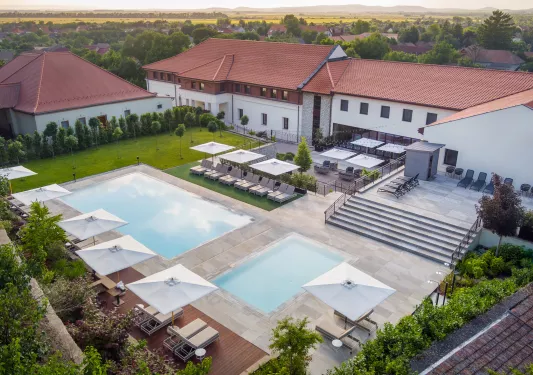 Exterior view of an outdoor pool in front of a large hotel building