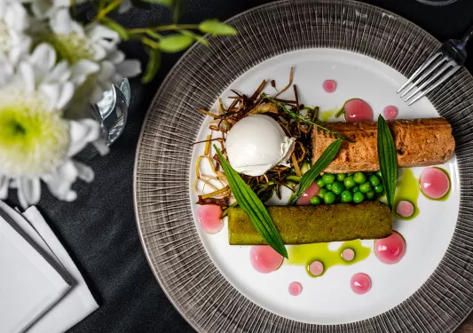 Fancy plate of grilled fish with vegetables and garnishes