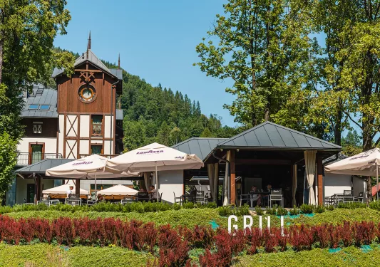 Outdoor patio with large umbrellas and trees surrounding the area