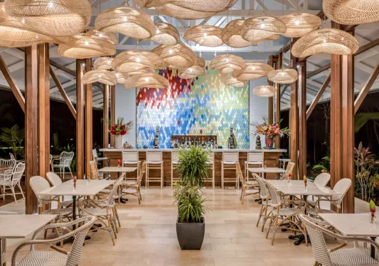 Hotel dining room and bar with structural light fixtures hanging from the cieling