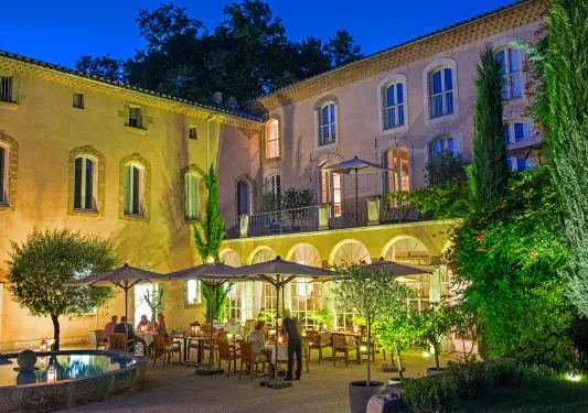 Outdoor patio with dining tables illuminated with warm lights