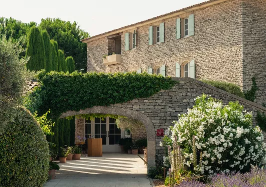 Large, stone archway with plants and trees to the left