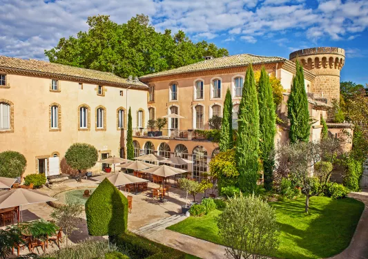 Exterior view of tan colored, stone building with a small garden in front