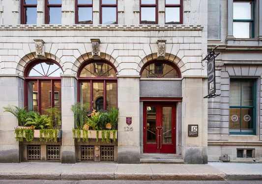 White stone building entrance with a red door