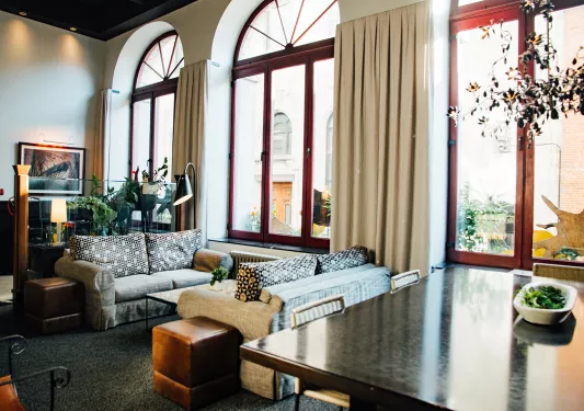 Seating and lounge area with large windows and tall curtains