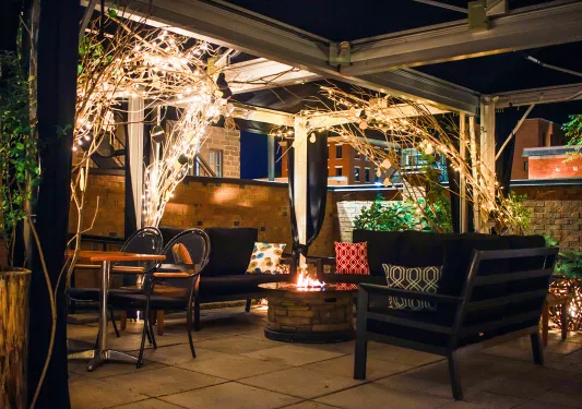 Outdoor patio and seating area with a fire pit in the center