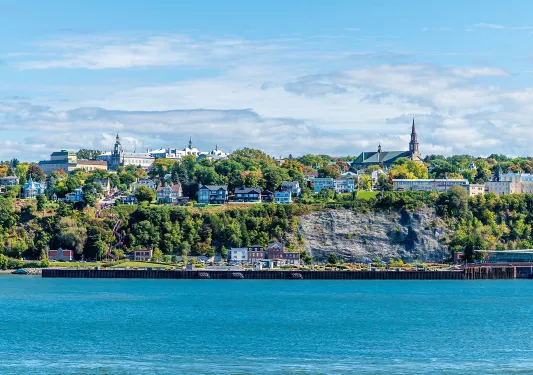Exterior view of a small town with houses in front of a large lake
