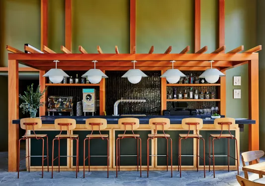 Bar with blue counter and wooden stools in front