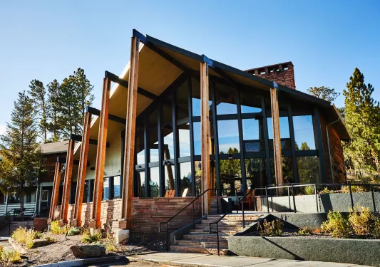 Exterior view of hotel building with large wooden pillars and large windows