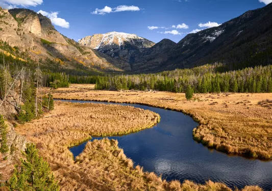 River cutting through a valley with large mountains in the distance