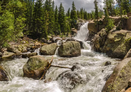 Active river with water hitting large boulders