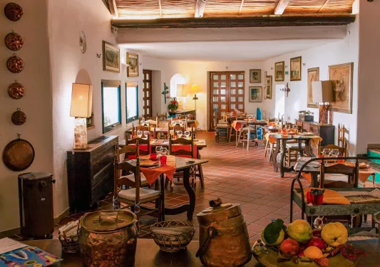 Indoor restaurant with wooden dining tables with paintings on the walls