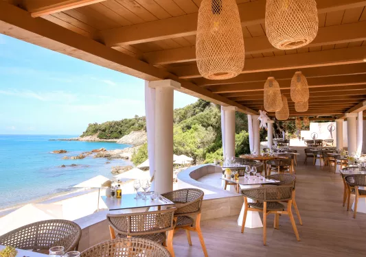 Outdoor patio with large wooden sunshade, with views of the ocean to the left