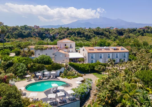 Outdoor, sky view of a hotel complex with an outdoor pool and large forest
