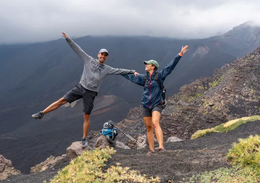 Two backroads guest pose with their hands up on a hike