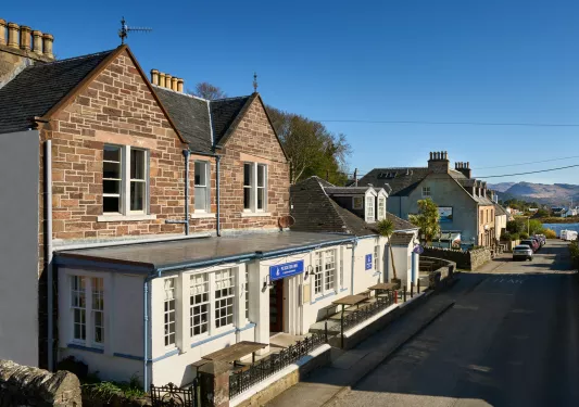 Exterior view of brick hotel building with a river in the distance