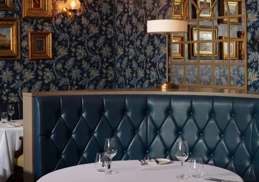 Dining table with dark blue sofa and wine glasses on the table