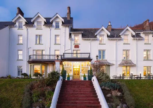 Exterior view of white hotel building with a red staircase in front