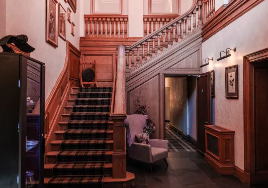 Building corridor with a large staircase to the left and a chair to the right