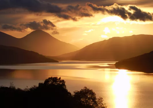 Lake and mountains with the sunset in the distance