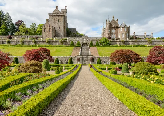 Large outdoor garden with a staircase leading up to rustic stone buildings