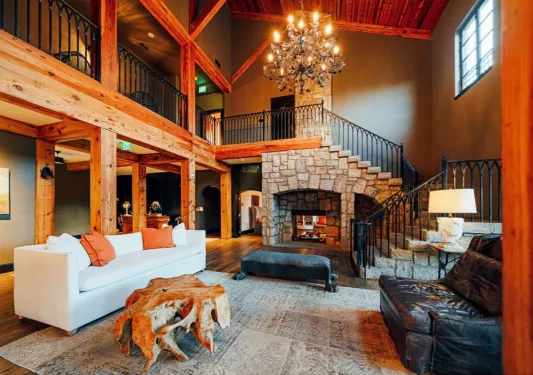 Wood cabin with large couch in front of fireplace