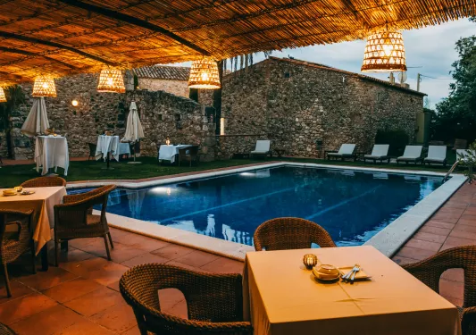 Outdoor pool with dining tables surrounding the area