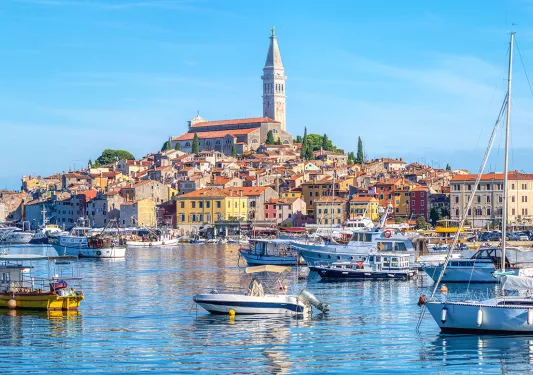 Ocean full of floating boats and a town on a small island