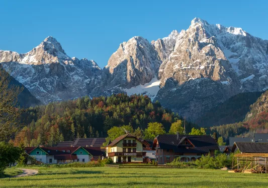 Exterior view of hotel complex buildings in a valley, with large mountains in the distance