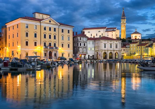 River leading up towards a town, illuminated by warm lights