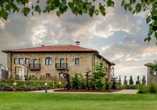 Exterior view of brick hotel building with grass field in front