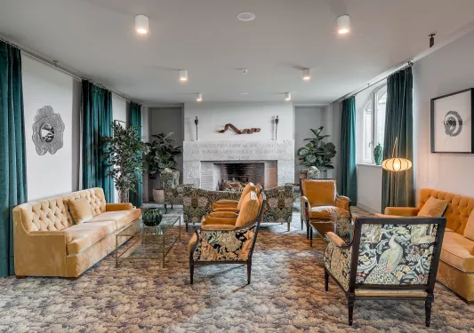 Indoor lobby and seating are with cushioned sofas and a stone fireplace