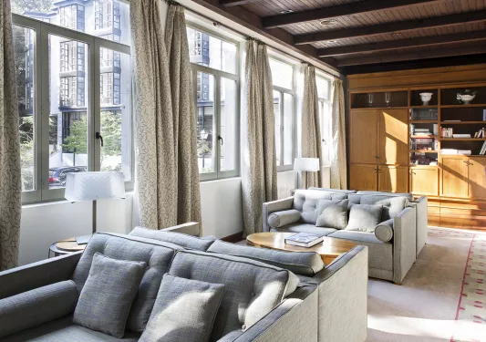 Seating area with gray, cushioned chairs and large windows