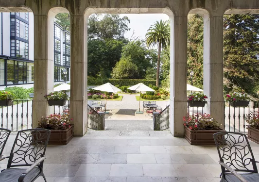 Outdoor courtyard with metal chairs and tables under umbrellas