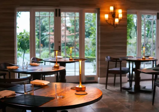 Dining area with circular tables and small lamps on each table