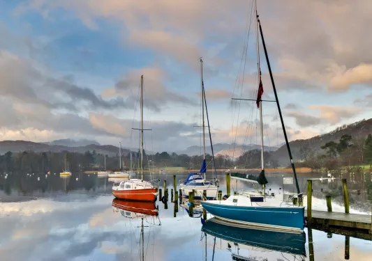 Boats docked on a bridge by the shore