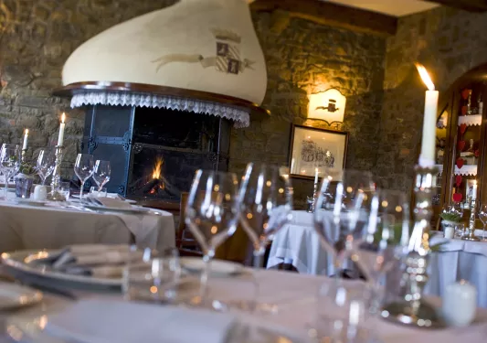 Dining hall with stone walls and wine glasses on each table