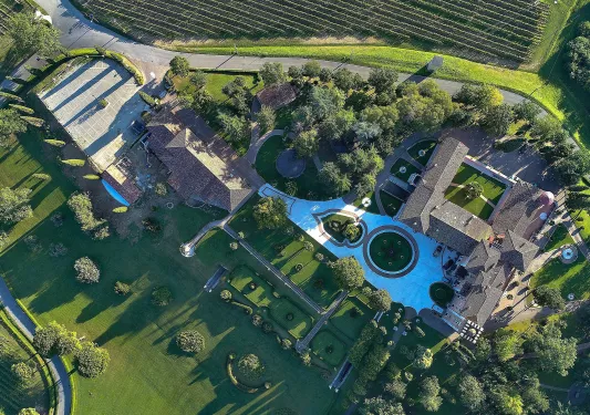 Sky view of a large building complex with large gardens and crop valleys