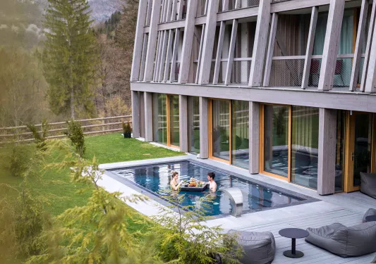 Outdoor pool with two people eating from a floating table