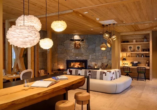 Indoor lobby with stone walls and wooden pillars and fluffy light fixtures